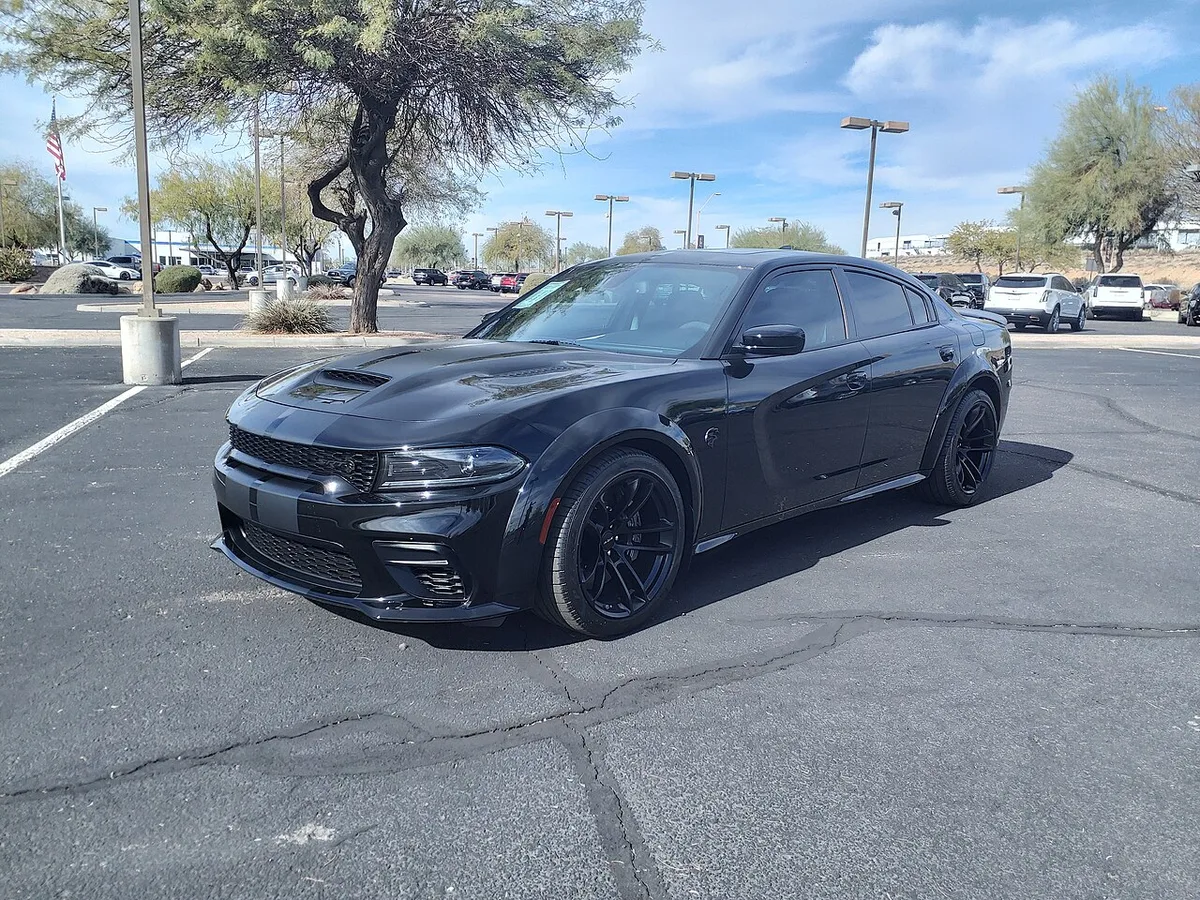 A black 2022 Dodge Charger SRT Hellcat Redeye Jailbreak Widebody sedan seen from the front three-quarter angle in a parking lot
