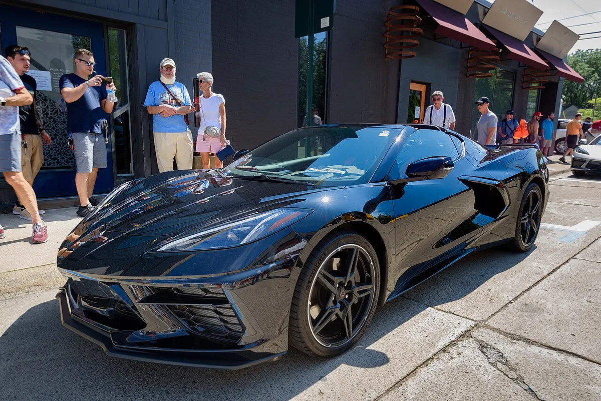 A black 2020 Chevrolet Corvette C8 Stingray seen from the front three-quarter angle on a city street