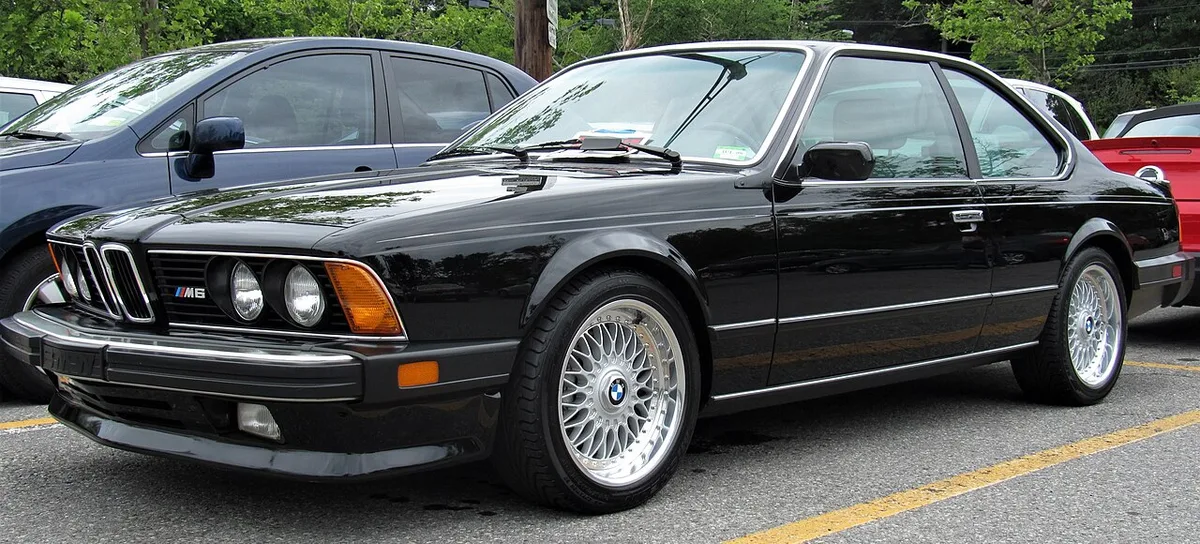 A black 1987 BMW M6 coupe, the North American version of the M635CSi, with M6 grille badge and cross-spoke wheels