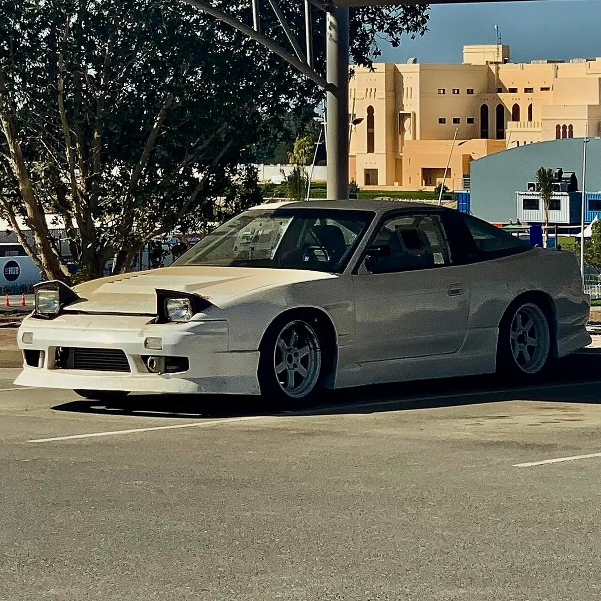 A white Nissan 180SX S13 parked