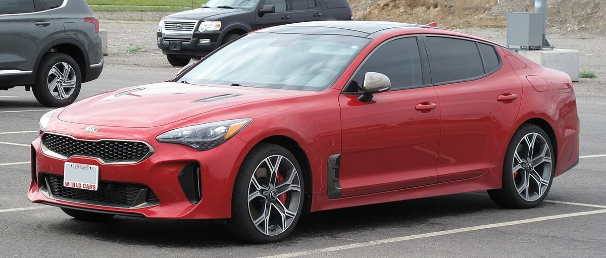 A red 2018 Kia Stinger GT sedan seen from the front three-quarter angle