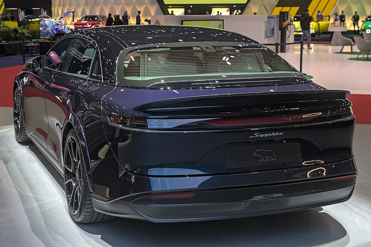 Rear three-quarter view of a dark blue Lucid Air Sapphire on a motor show stand
