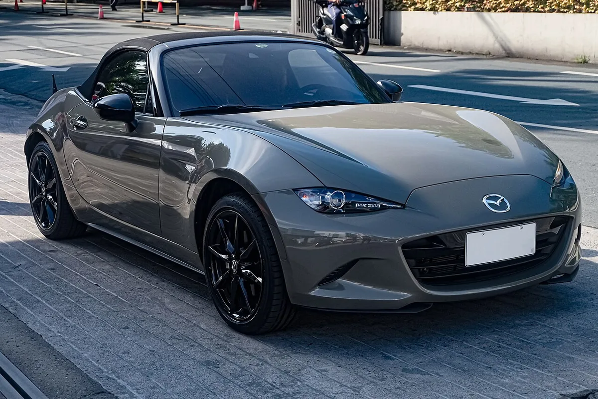 An Aero Gray ND Mazda MX-5 convertible with black wheels