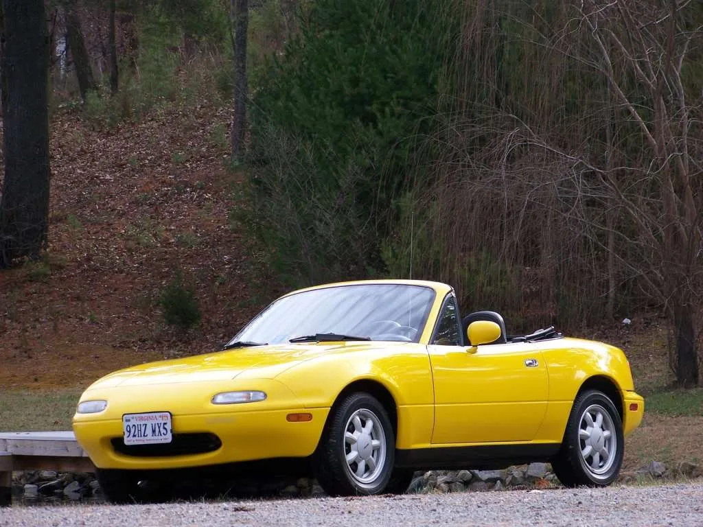 A Sunburst Yellow NA Mazda MX-5 Miata convertible