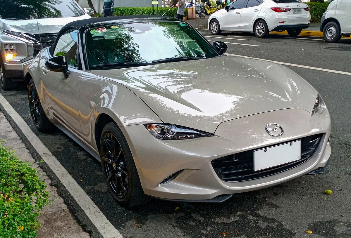 A Zircon Sand ND Mazda MX-5 with a black soft top