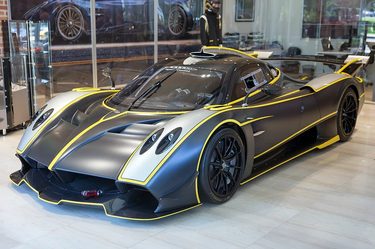 A carbon Pagani Huayra R track car with yellow accents from the front three-quarter view