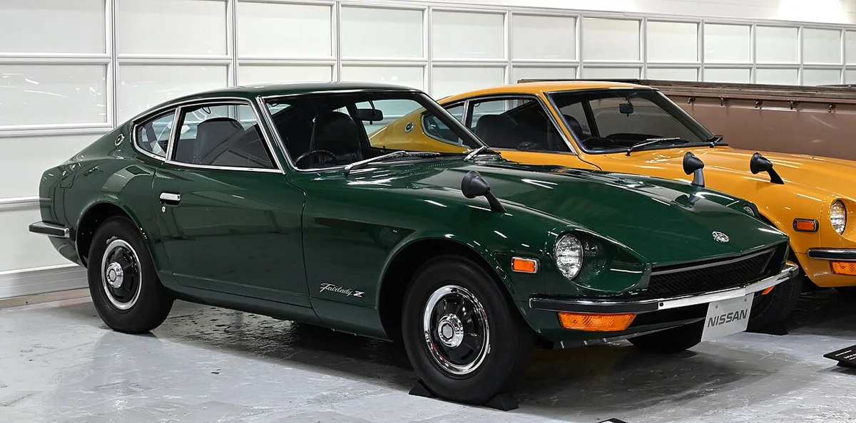 A dark green 1970 Nissan Fairlady Z-L, the S30 generation, shown from the front three-quarter with its long hood